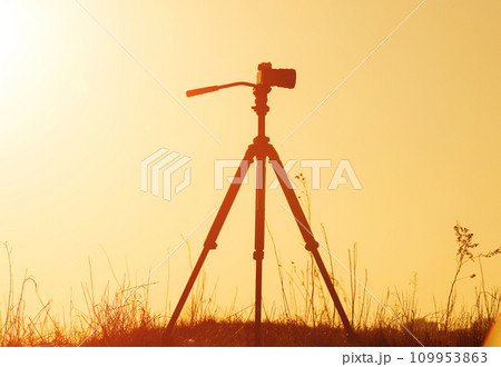 Silhouette of camera on tripod at sunset Silhouette of camera on tripod at sunset 109953863