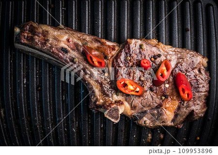 Grilled bone-in ribeye steak with chili Grilled bone-in ribeye steak with chili 109953896