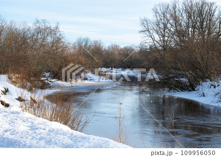 Small narrow river in winter, river bend, water reflections. 109956050