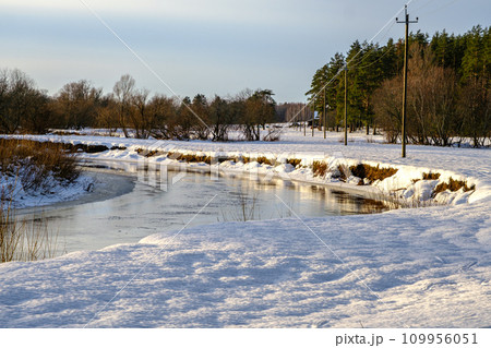 Small narrow river in winter, river bend, water reflections. 109956051