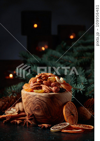 Christmas still-life with dried fruits, nuts, and burning candles. Christmas still-life with dried fruits, nuts, and burning candles. 109956481