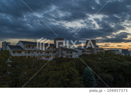 住宅街の中にある夕焼け空 住宅地の夕焼け　マンション　公団　照明　公団住宅　夕焼け　夜景　集合住宅　 109957373