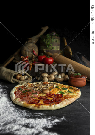 Italian Pizza Four Seasons (Pizza Quattro Stagioni) with different ingredients on the wooden table in the kitchen Italian Pizza Four Seasons (Pizza Quattro Stagioni) with different ingredients on the wooden table in the kitchen 109957595