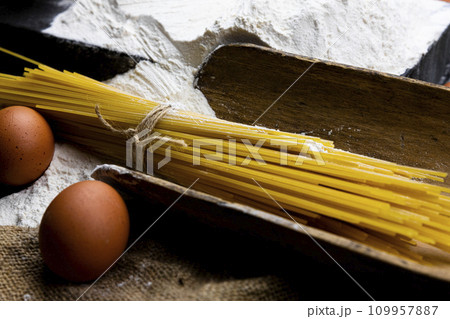 Fresh uncooked Spaghetti and pasta ingredients on a rustic table Fresh uncooked Spaghetti and pasta ingredients on a rustic table 109957887