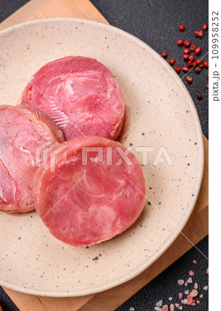 Round shape steaks of raw juicy tuna with salt and spices Round shape steaks of raw juicy tuna with salt and spices 109958252