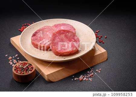 Round shape steaks of raw juicy tuna with salt and spices Round shape steaks of raw juicy tuna with salt and spices 109958253