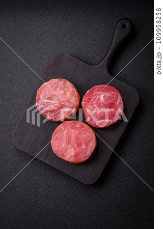 Round shape steaks of raw juicy tuna with salt and spices Round shape steaks of raw juicy tuna with salt and spices 109958258