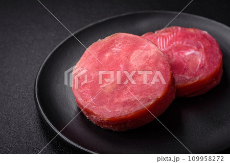 Round shape steaks of raw juicy tuna with salt and spices 109958272
