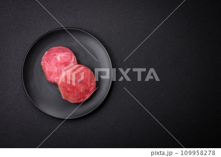 Round shape steaks of raw juicy tuna with salt and spices Round shape steaks of raw juicy tuna with salt and spices 109958278