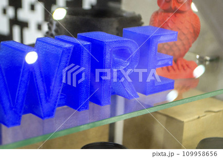 Objects letters printed on 3D printer close-up. Models letter 3D printed from molten plastic blue color. FDM technologies. Additive progressive modern new technology. 3D printing innovation technology 109958656