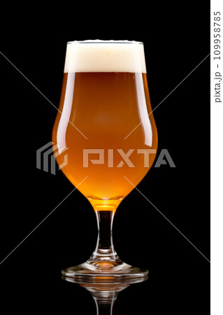 Beer in a tall glass on a dark black background. Mugs with drink like Ipa, Pale Ale, Pilsner, Porter or Stout Beer in a tall glass on a dark black background. Mugs with drink like Ipa, Pale Ale, Pilsner, Porter or Stout 109958785