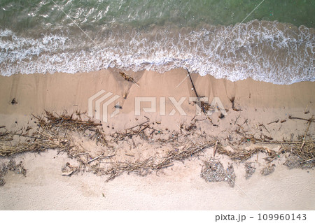 An top view of a polluted beach. Ocean waves bring garbage to the shore.The problem of ecology and pollution of nature and the planet. 109960143