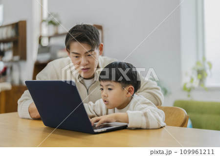 ノートパソコンの画面を見る親子 109961211