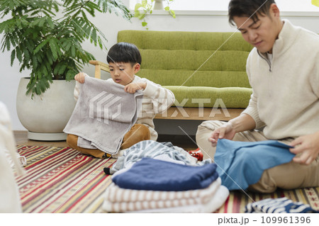 洗濯物をたたむ親子　30代の父親と7歳の男の子 109961396