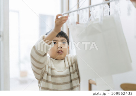 牛乳パックのリサイクル 洗った紙パックを乾かす男の子 牛乳パックのリサイクル 洗った紙パックを乾かす男の子 109962432