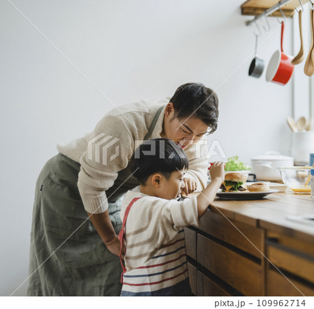 チーズバーガーを作る父親と7歳の息子 109962714