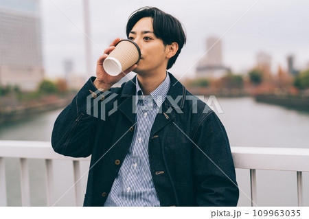 冬の屋外でコーヒーを飲む男性 109963035