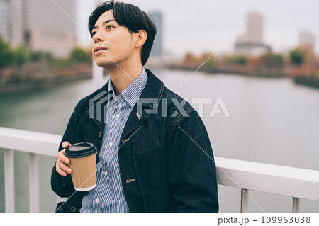 冬の屋外でコーヒーを飲む男性 109963038