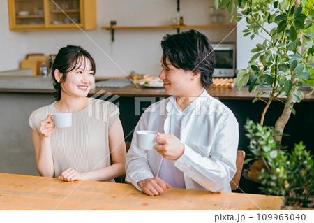家のダイニングで会話する仲良しの若い日本人夫婦 家のダイニングで会話する仲良しの若い日本人夫婦 109963040