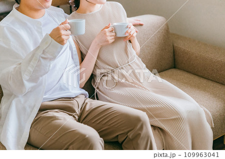 家のリビング・ソファで会話する仲良しの若い日本人夫婦 109963041