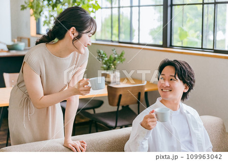 家のリビング・ソファで会話する仲良しの若い日本人夫婦 家のリビング・ソファで会話する仲良しの若い日本人夫婦 109963042