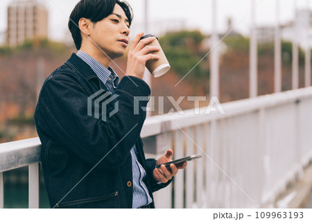 橋の上でコーヒーを飲む男性 109963193