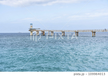 部瀬名の青い海と海中展望塔に向かう橋　ブセナ海中公園　沖縄県名護市 109964013