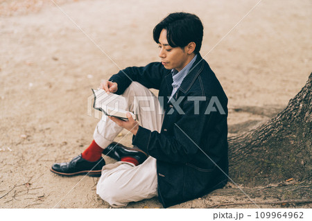 屋外で本を読む男性 109964962
