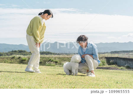 愛犬を可愛がる飼い主の親子・犬の散歩（父親と娘） 109965555