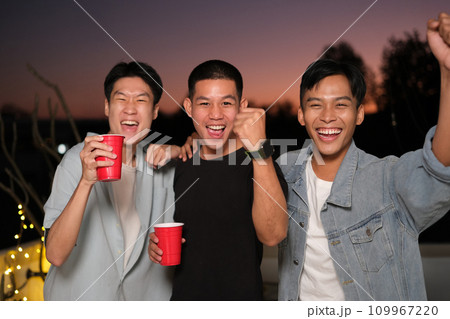 Group of young friends laughing and having fun at rooftop party. 109967220