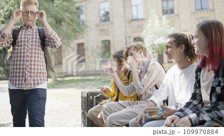 School kids laughing at insecure plump classmate in eyeglasses, weight bullying School kids laughing at insecure plump classmate in eyeglasses, weight bullying 109970884