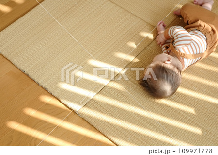 畳の上で寝転がって遊ぶ赤ちゃん 109971778