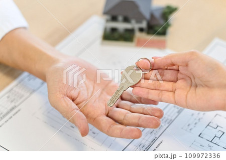家の鍵を渡す女性の手元 109972336