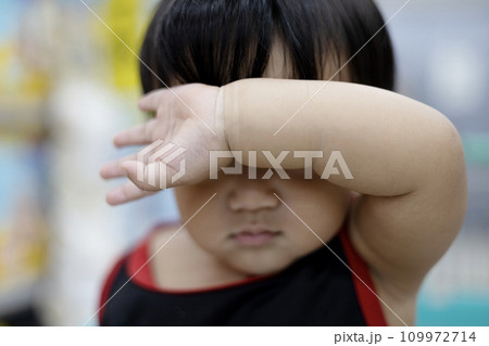 Cute boy holding his right arm on the front as protecting from sun. Boy Holding His Arm In Front Of His Face. Cute boy holding his right arm on the front as protecting from sun. Boy Holding His Arm In Front Of His Face. 109972714