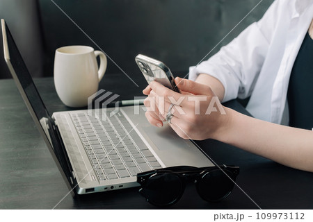 Professional Businesswomen Multitasking with Laptops and Smartphones in Modern Office. Diverse 109973112