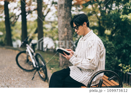 公園で本を読む男性 109973612