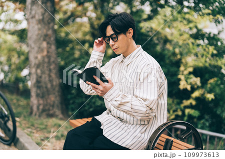 公園で本を読む男性 公園で本を読む男性 109973613