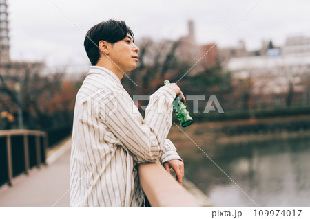 屋外でお酒を飲む男性 109974017