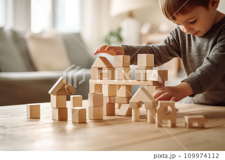 Cute little child playing with wooden blocks. Sustainable eco friendly toys 109974112