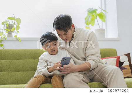 スマートフォンの画面を見る親子 お父さんと小学生の息子 スマートフォンの画面を見る親子 お父さんと小学生の息子 109974206