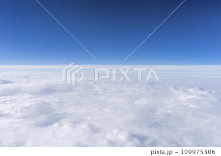 飛行機の窓から見た青空と雲海 109975306
