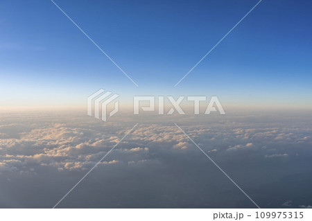 飛行機の窓から見た青空と雲海 109975315