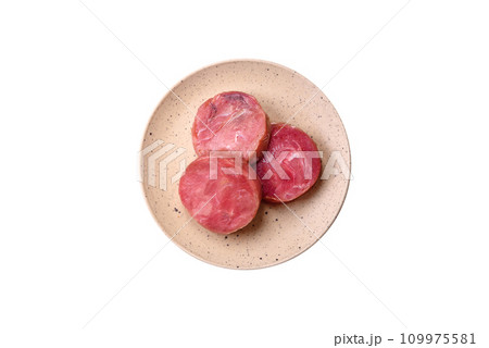 Round shape steaks of raw juicy tuna with salt and spices Round shape steaks of raw juicy tuna with salt and spices 109975581