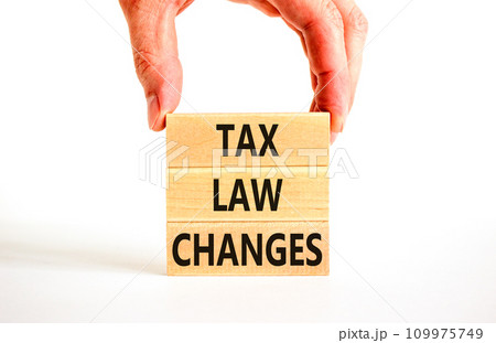 Tax law changes symbol. Concept words Tax law changes on wooden blocks on a beautiful white table white background. Businessman hand. Business tax law changes concept. Copy space. Tax law changes symbol. Concept words Tax law changes on wooden blocks on a beautiful white table white background. Businessman hand. Business tax law changes concept. Copy space. 109975749