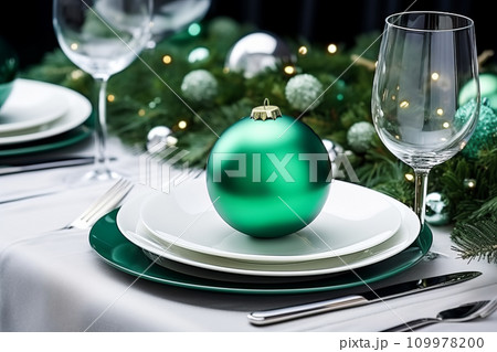Christmas table setting with minimal festive tableware and green decor for Christmas celebration Christmas table setting with minimal festive tableware and green decor for Christmas celebration 109978200