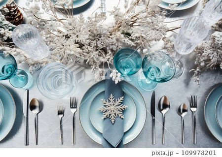 Christmas table setting with candles and crystal festive tableware and blue decor for Christmas celebration 109978201