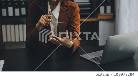 Asian Businesswoman Using laptop computer and working at office with calculator document on desk, doing planning analyzing the financial report, business plan investment, finance analysis concept. Asian Businesswoman Using laptop computer and working at office with calculator document on desk, doing planning analyzing the financial report, business plan investment, finance analysis concept. 109978294