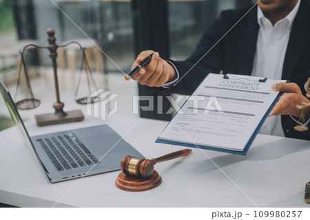 Business and lawyers discussing contract papers with brass scale on desk in office. Law, legal services, advice, justice and law concept picture with film grain effect Business and lawyers discussing contract papers with brass scale on desk in office. Law, legal services, advice, justice and law concept picture with film grain effect 109980257