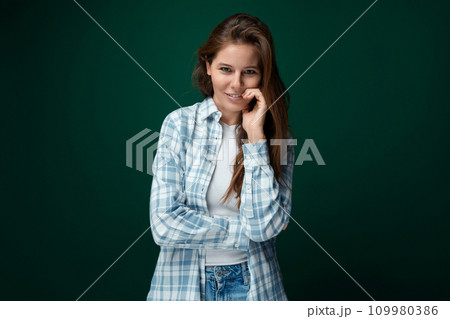 Carefree Caucasian young woman dressed in casual clothes on green studio background Carefree Caucasian young woman dressed in casual clothes on green studio background 109980386