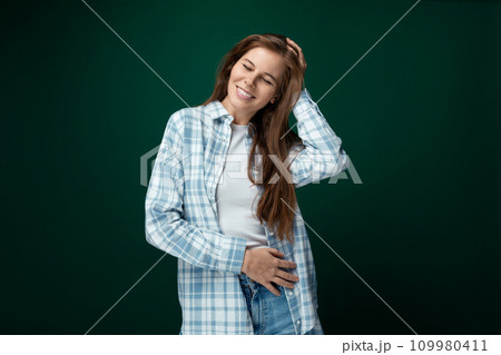 Portrait of a well-groomed young lady with natural brown hair on a green background Portrait of a well-groomed young lady with natural brown hair on a green background 109980411